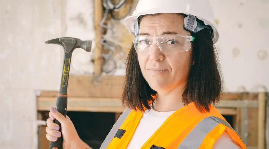 Femme tenant un marteau pour la rénovation de sa cuisine au Québec